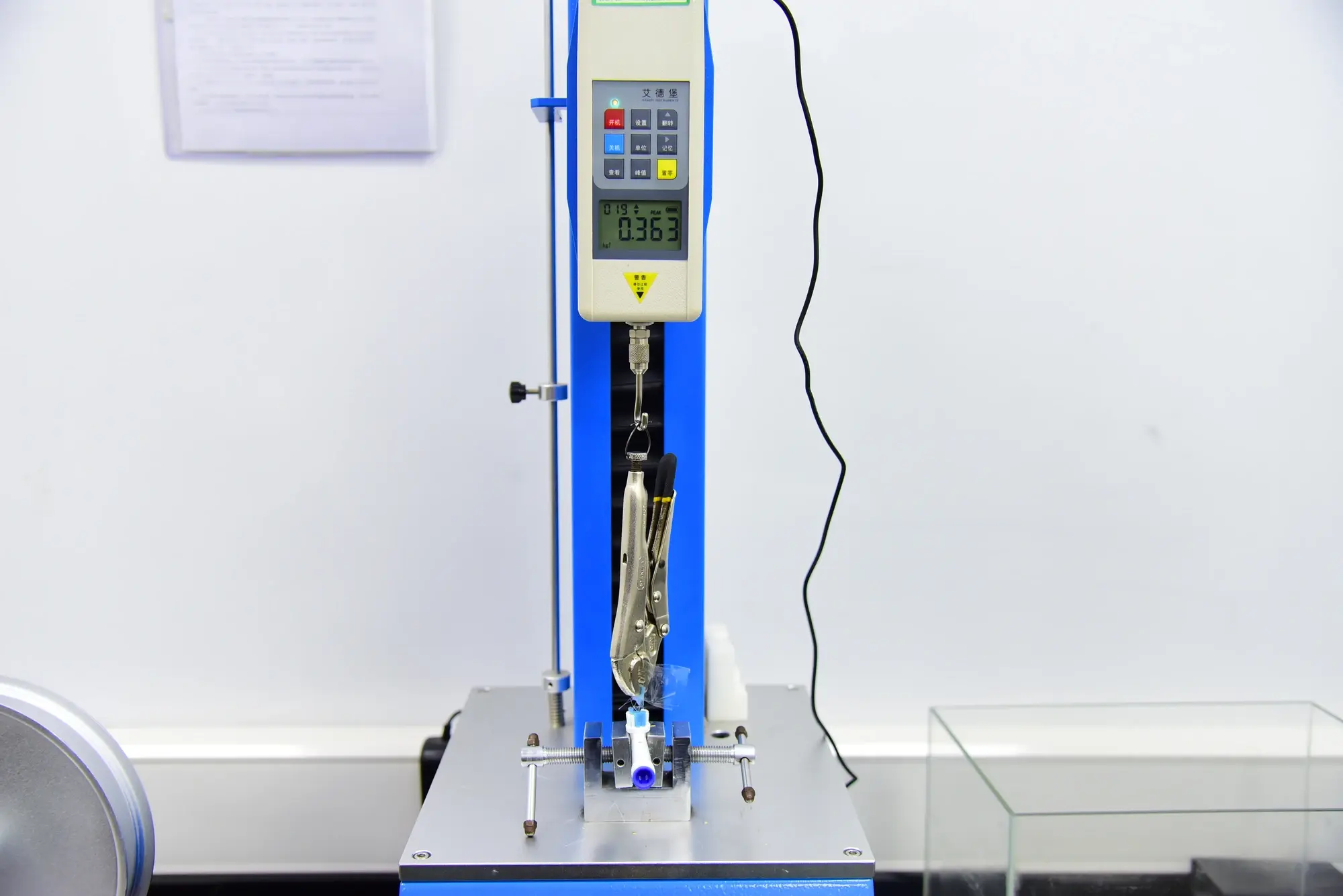 Tensile test equipment performing a pull test on a brush head sample at AileCare