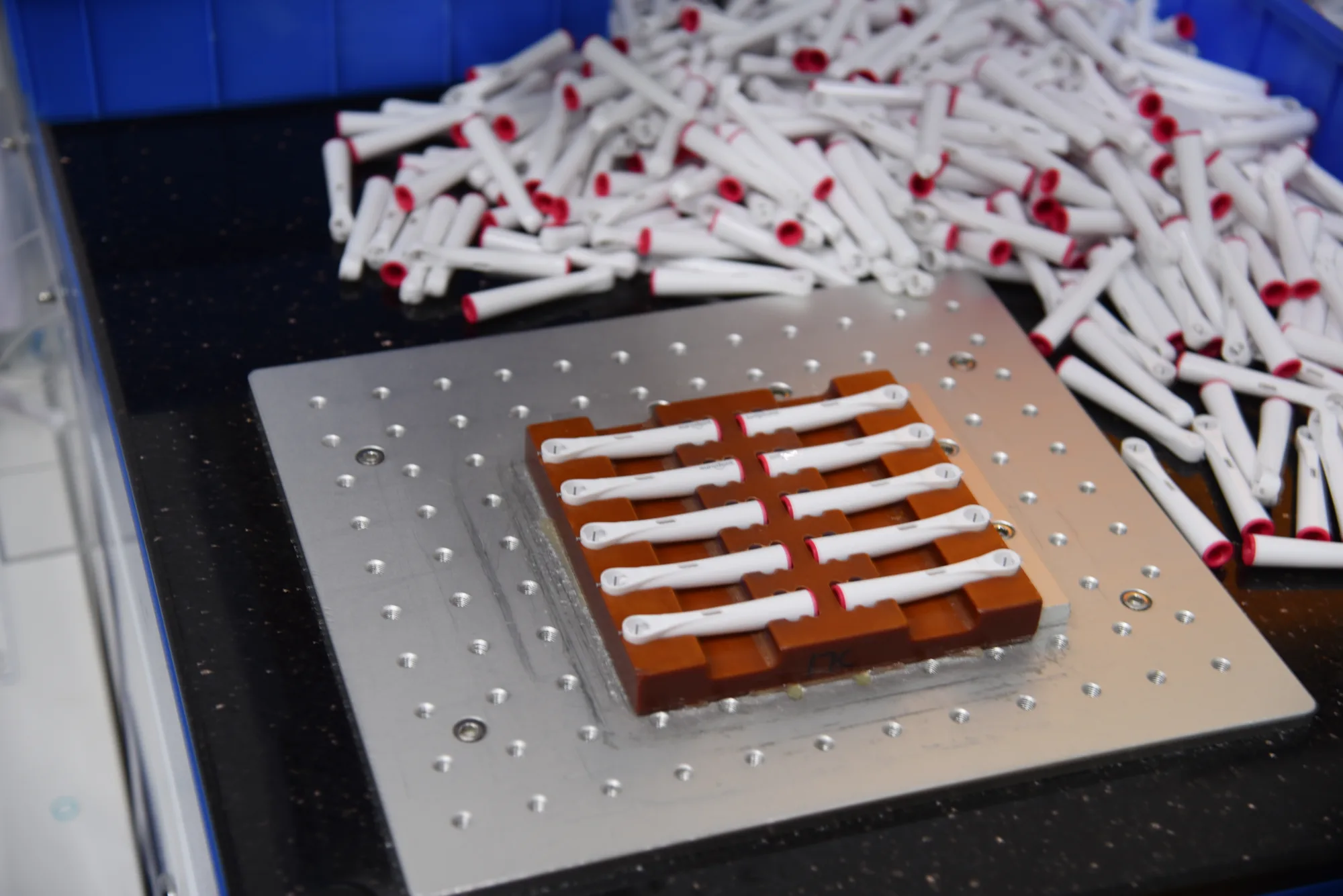 Electric toothbrush brand product samples arranged on a production fixture at the AileCare factory