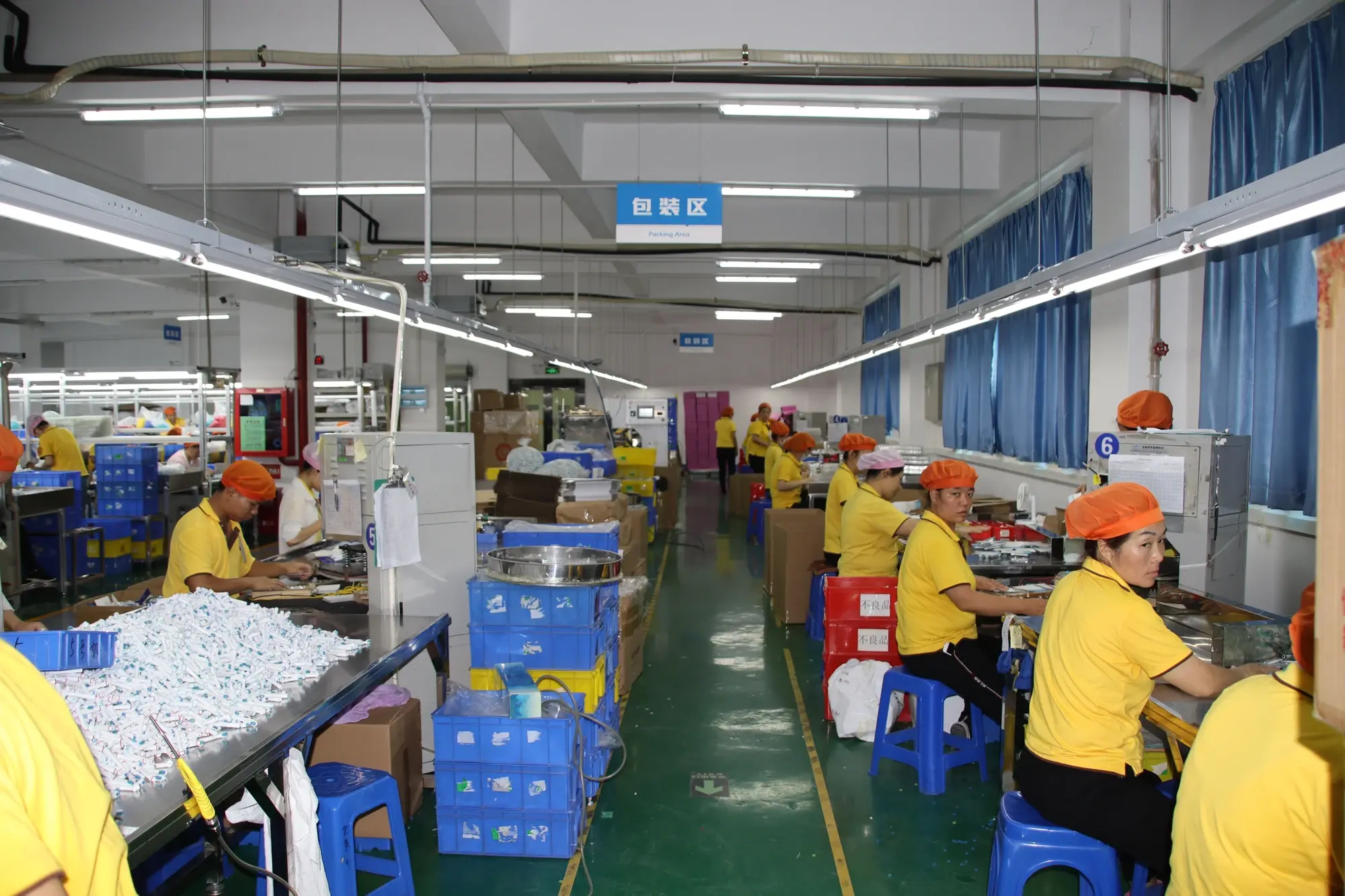 Worker assembling small electric toothbrush brush head components at an AileCare workbench